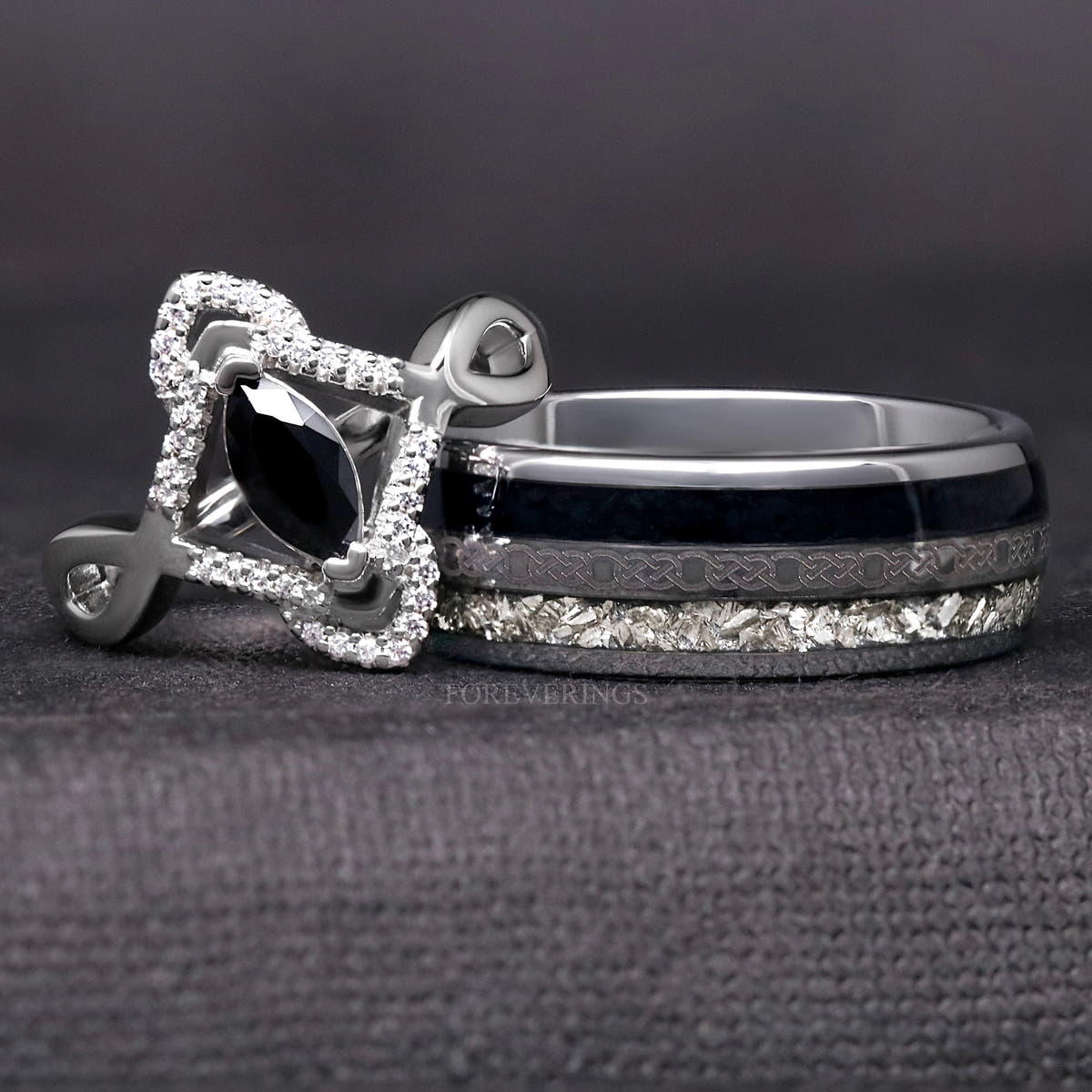 Sterling silver marquise black stone ring with a white stone halo beside a wide silver tungsten band