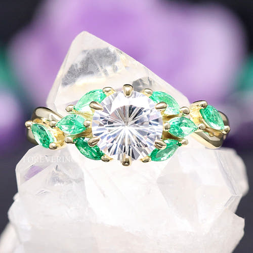 Women's gold sterling silver round white sapphire engagement ring with marquise emerald accents, close-up
