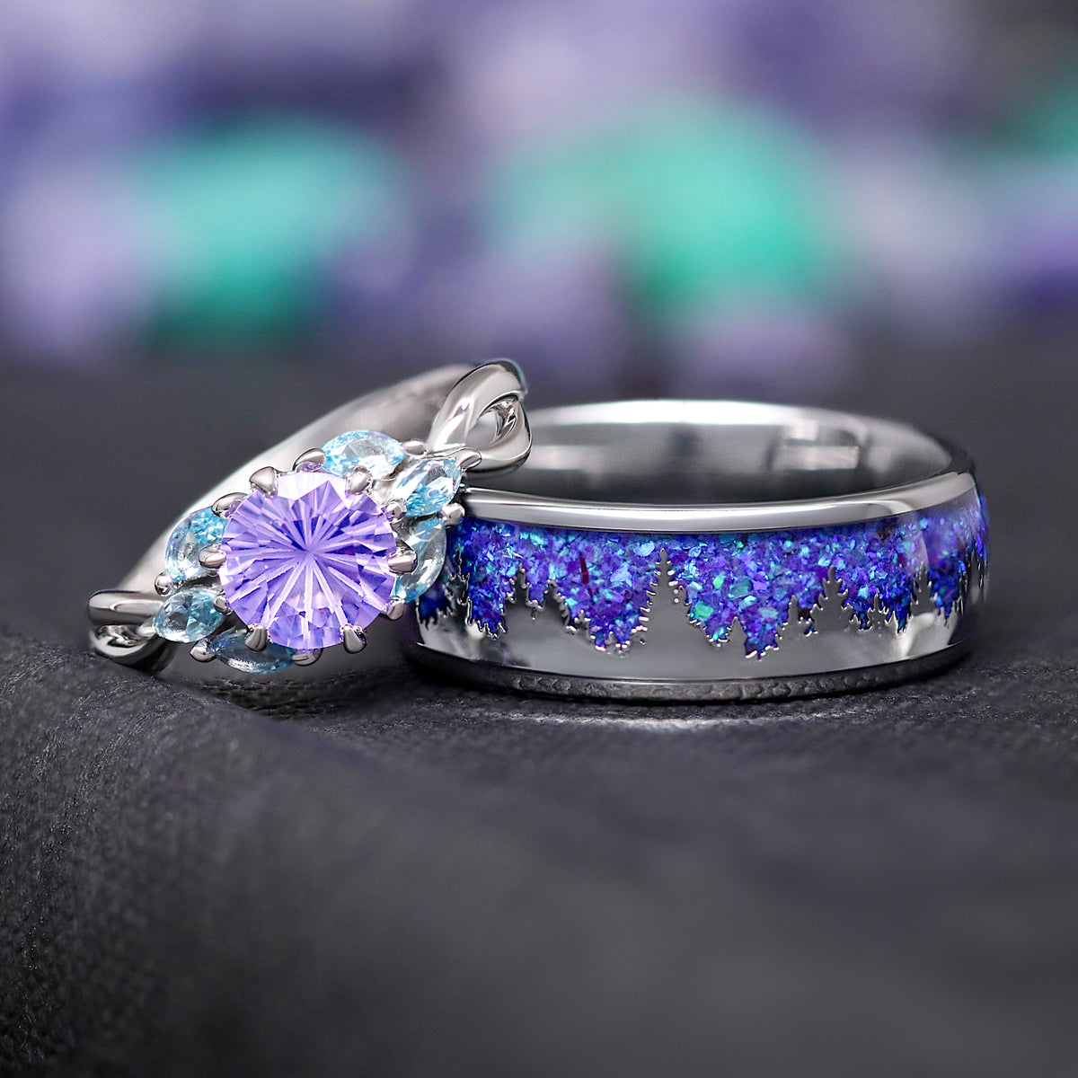 His and hers wedding ring set with an amethyst engagement ring leaning on a silver tungsten band