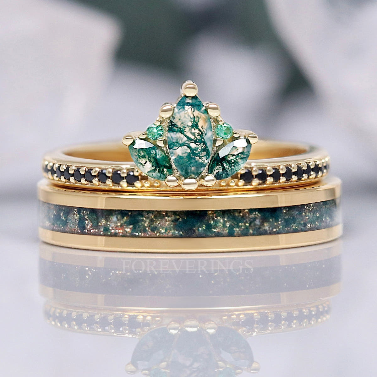 Women's gold lotus crown engagement ring with marquise moss agate, stacked on a moss agate inlay band