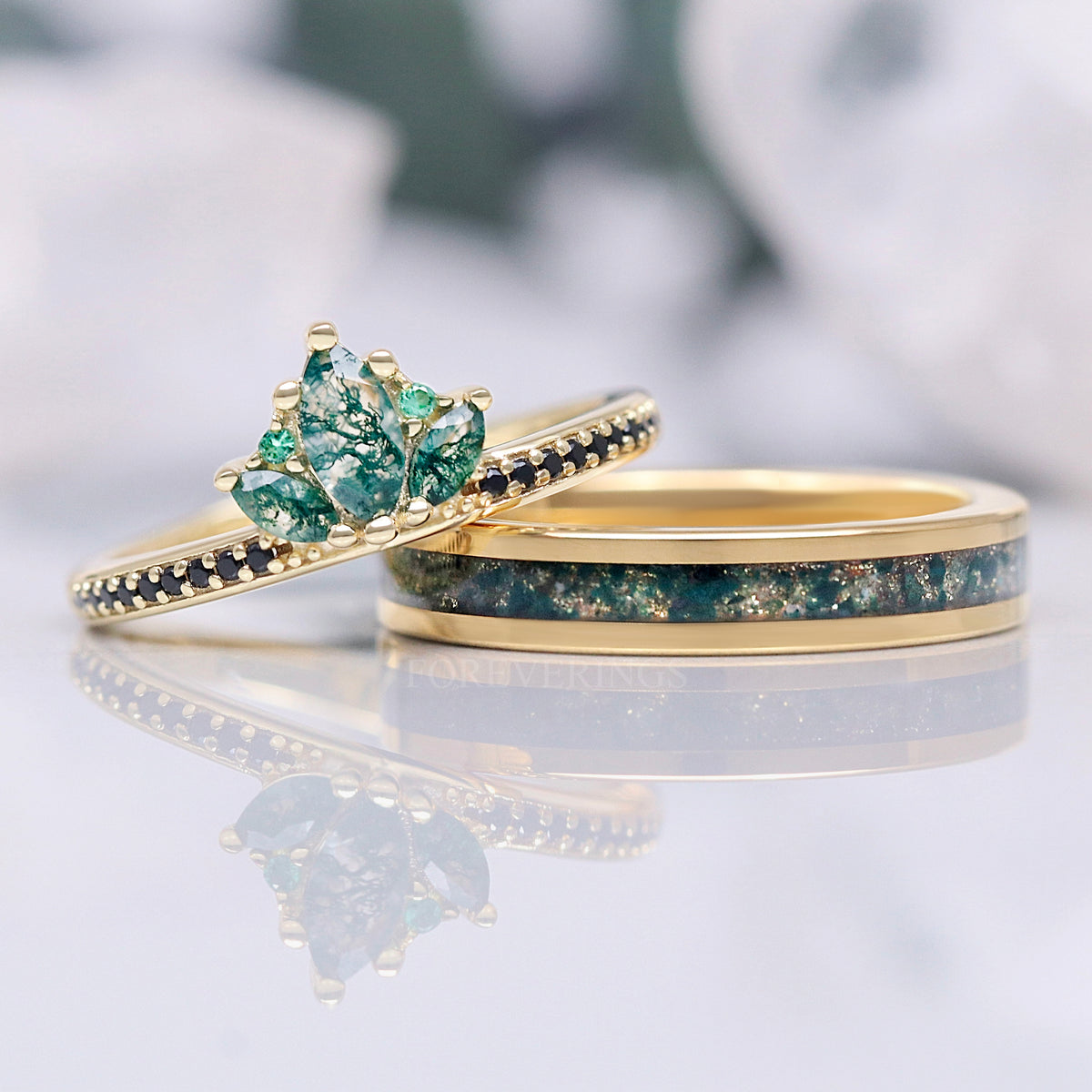 Moss agate lotus ring in gold leaning on a 4mm gold band with moss agate inlay