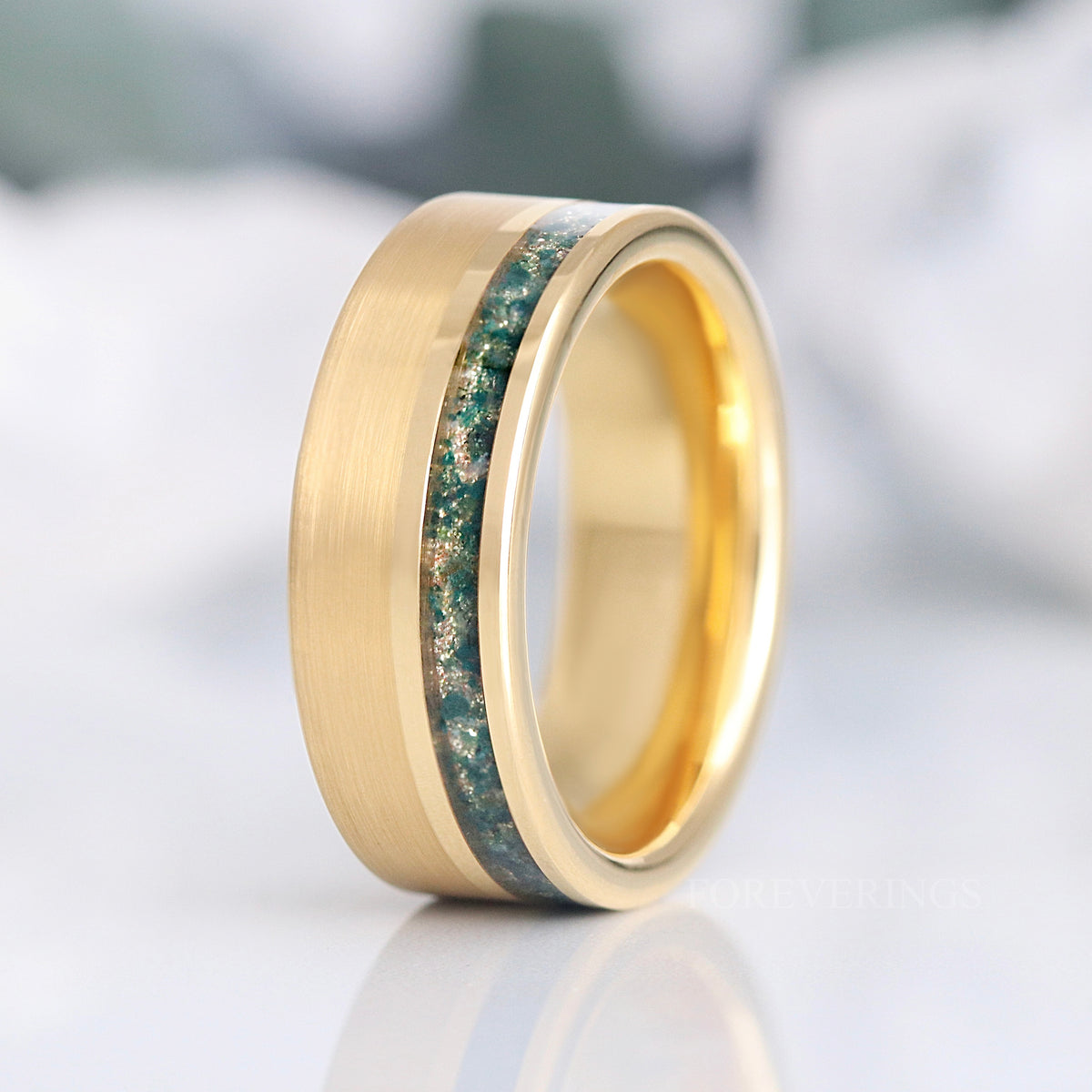 Men's 8mm matte gold tungsten band with a moss agate stripe near one edge, standing upright