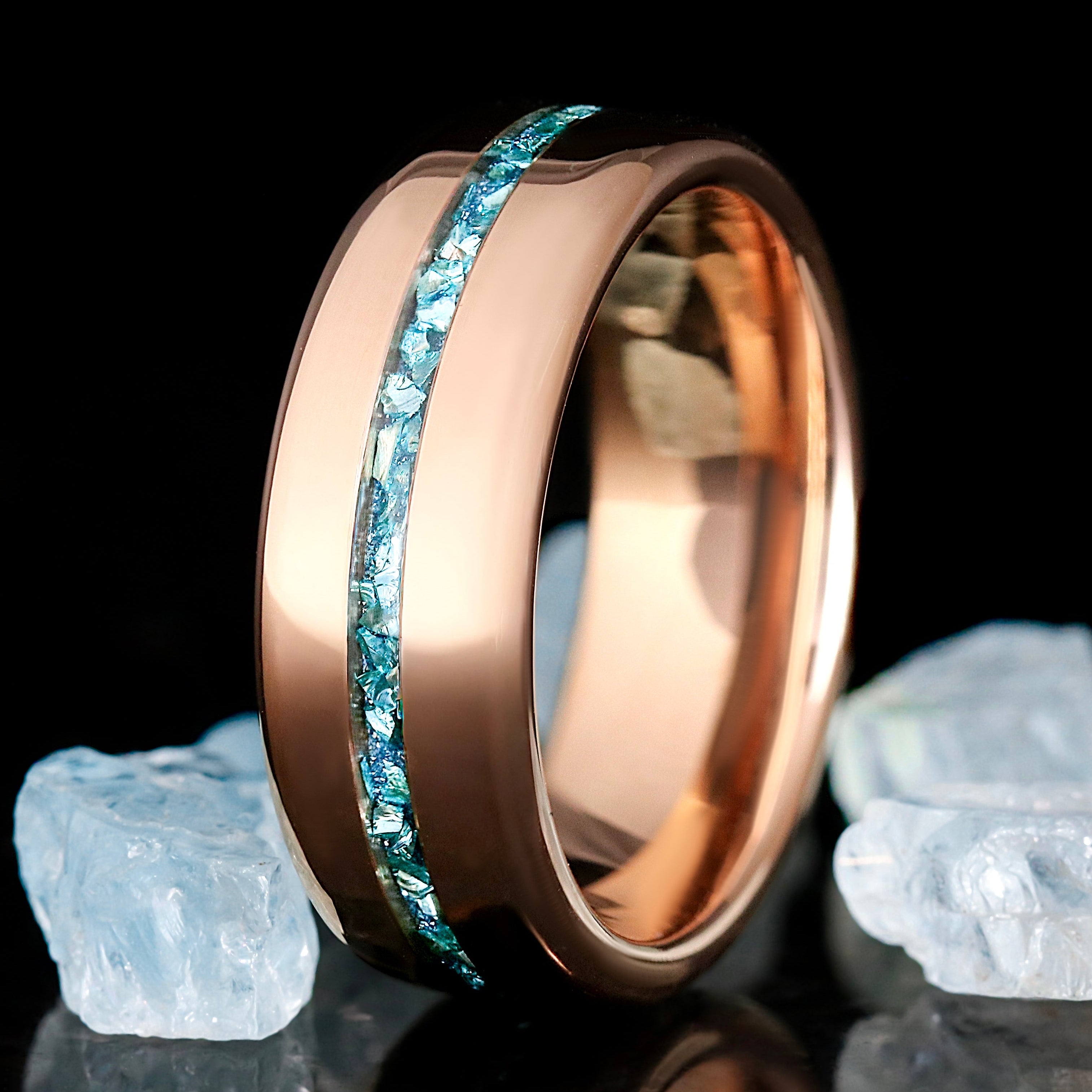 Rose gold ring with blue gemstones on a black background