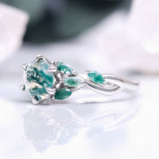 Women's sterling silver moss agate engagement ring with green leaf-shaped accents, angled view