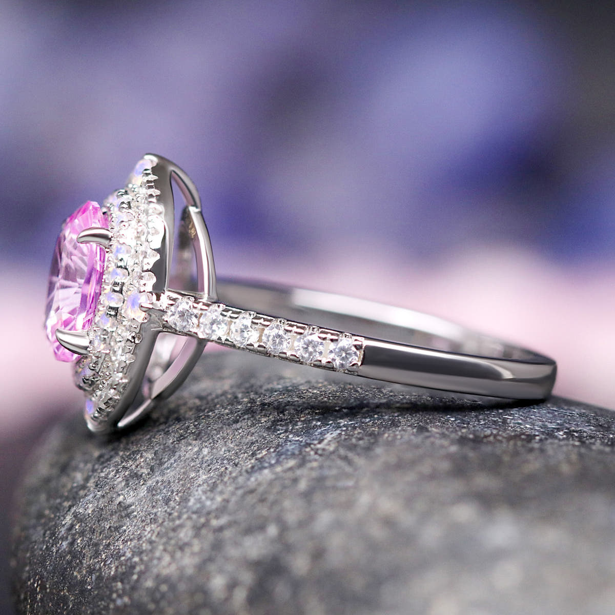 Sterling silver pink sapphire halo ring in side profile, showing the stone-lined band