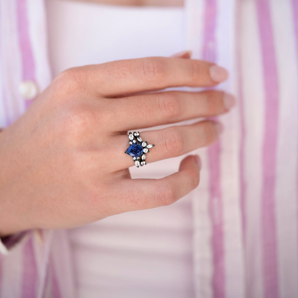 Women's black sterling silver pear-cut blue sandstone ring worn on a hand