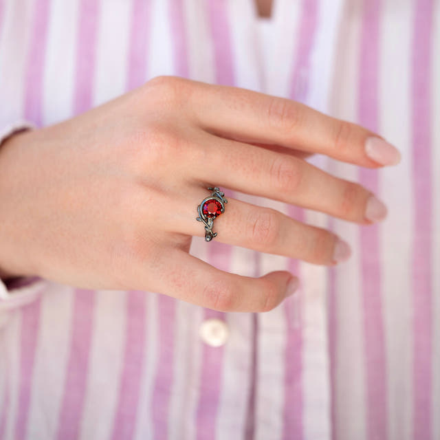 Rhodolite ring with a leaf vine band, worn on a woman's hand