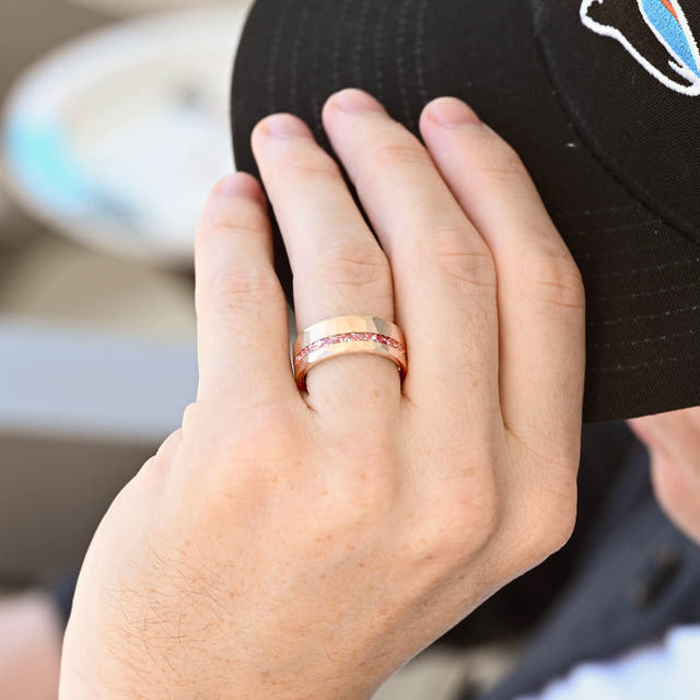 Rose gold tungsten band with crushed morganite inlay, worn on a man's hand