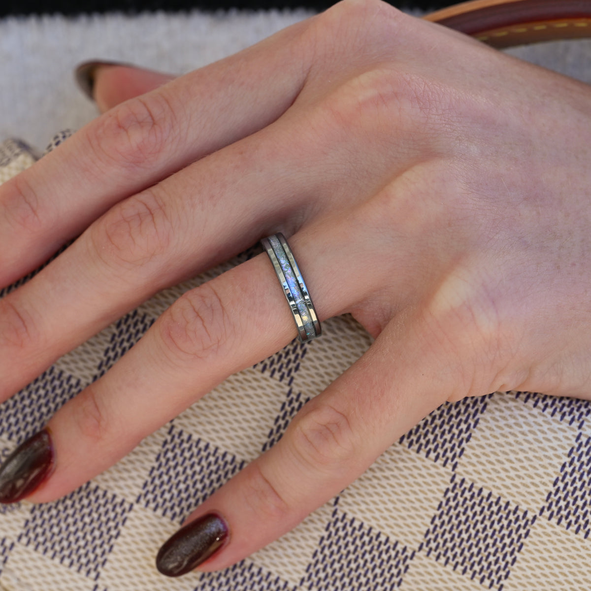 Women's 4mm silver tungsten ring with moonstone inlay worn on a hand