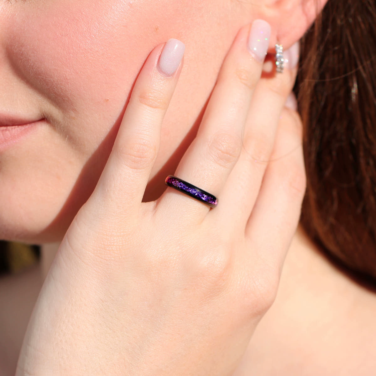 4mm black tungsten amethyst band worn on a hand, wider view