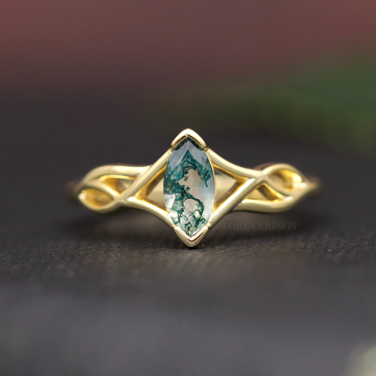 Women's gold sterling silver marquise moss agate ring with a twisted band, shown straight on