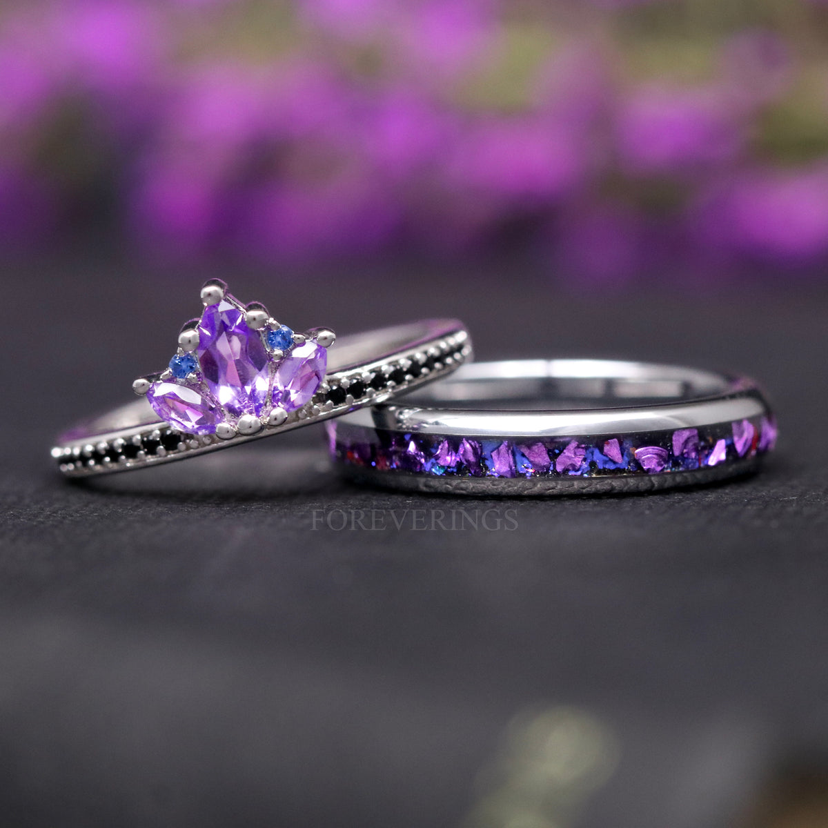 His and hers wedding ring set, the silver amethyst ring resting against the inlay band