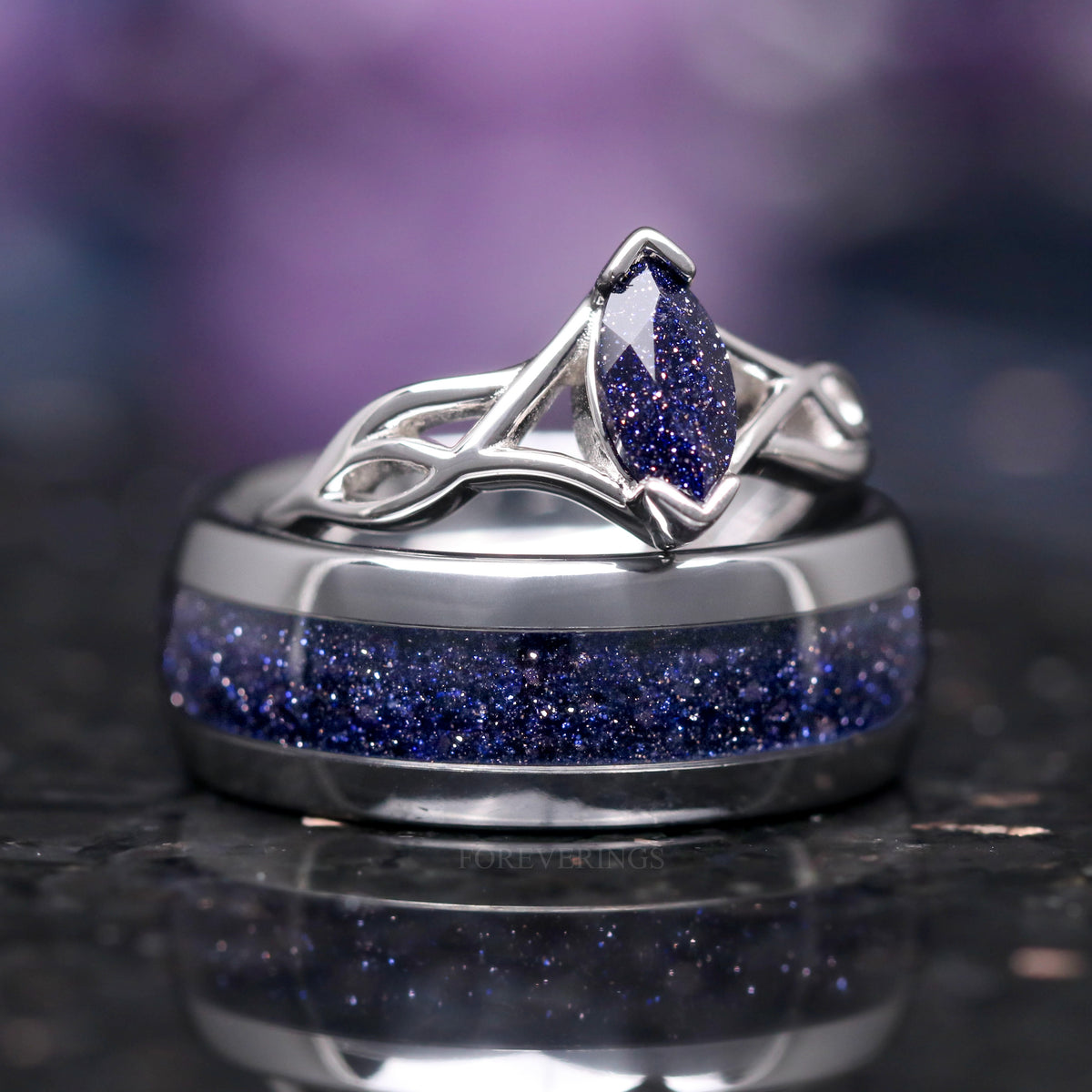 His and hers blue sandstone wedding ring set, marquise ring resting on top of the silver tungsten band