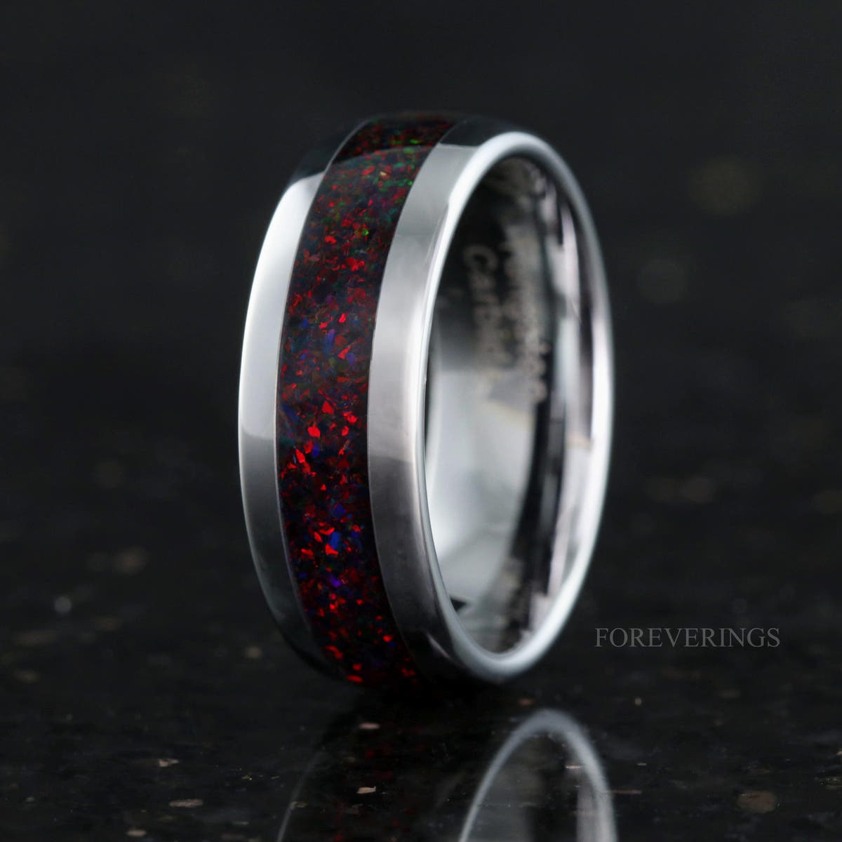Men's silver tungsten band with black fire opal inlay standing on edge, interior visible