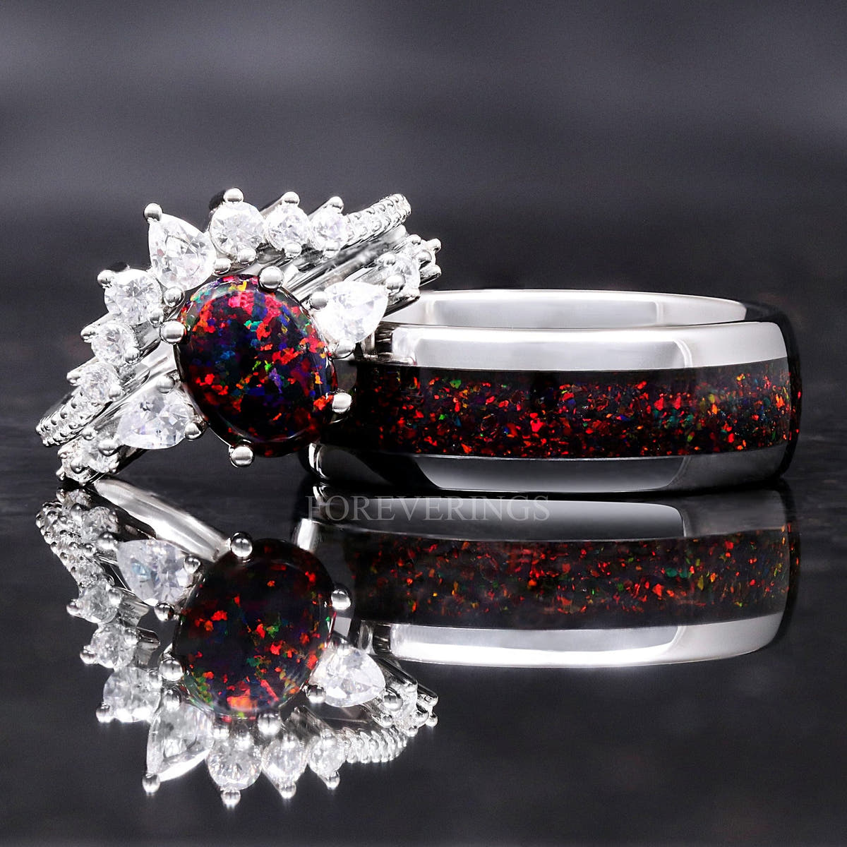 Couples ring set: black fire opal bridal set beside a wider silver tungsten band with the same opal inlay