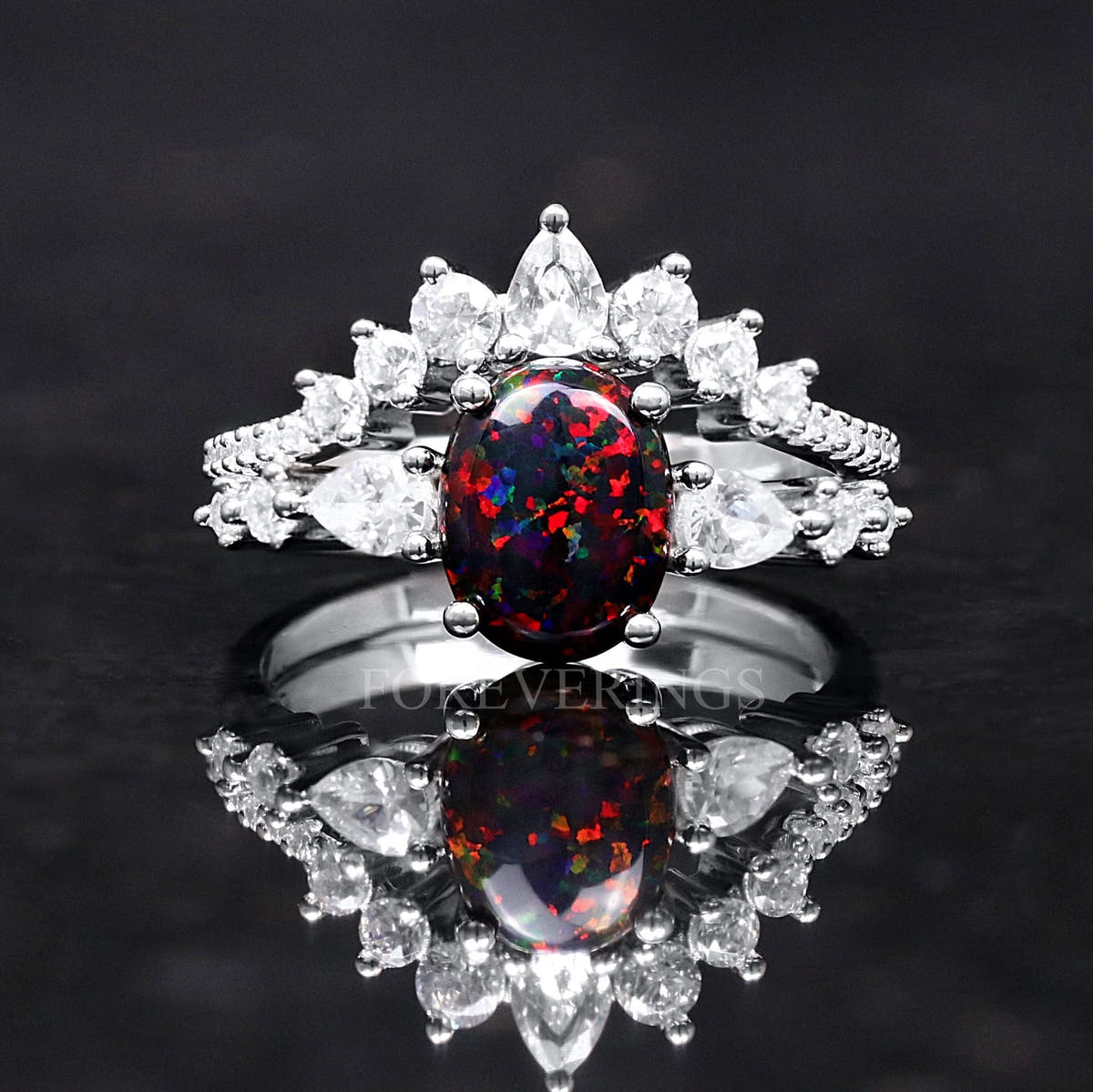 Women's sterling silver black fire opal bridal set shown straight on, with pear-cut white side stones