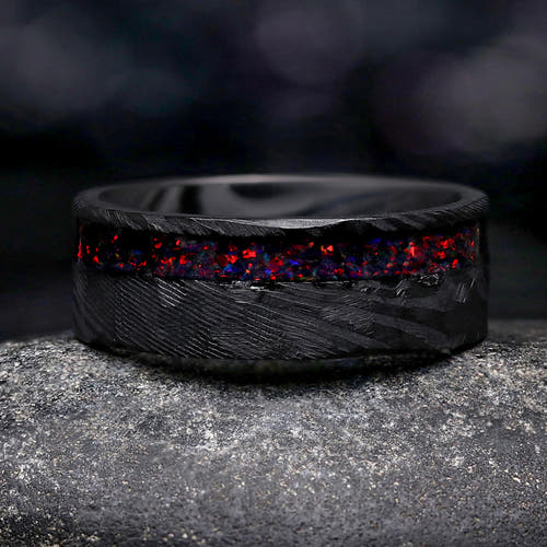 Men's 8mm hammered black Damascus steel wedding band with an offset black fire opal inlay
