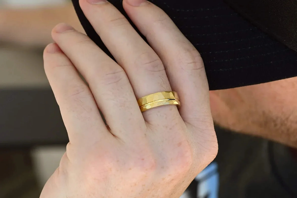 Hammered gold men's wedding band worn on his hand
