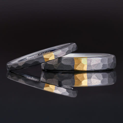 2mm and 4mm hammered silver tungsten bands with a gold strip, the thin one leaning on the wider