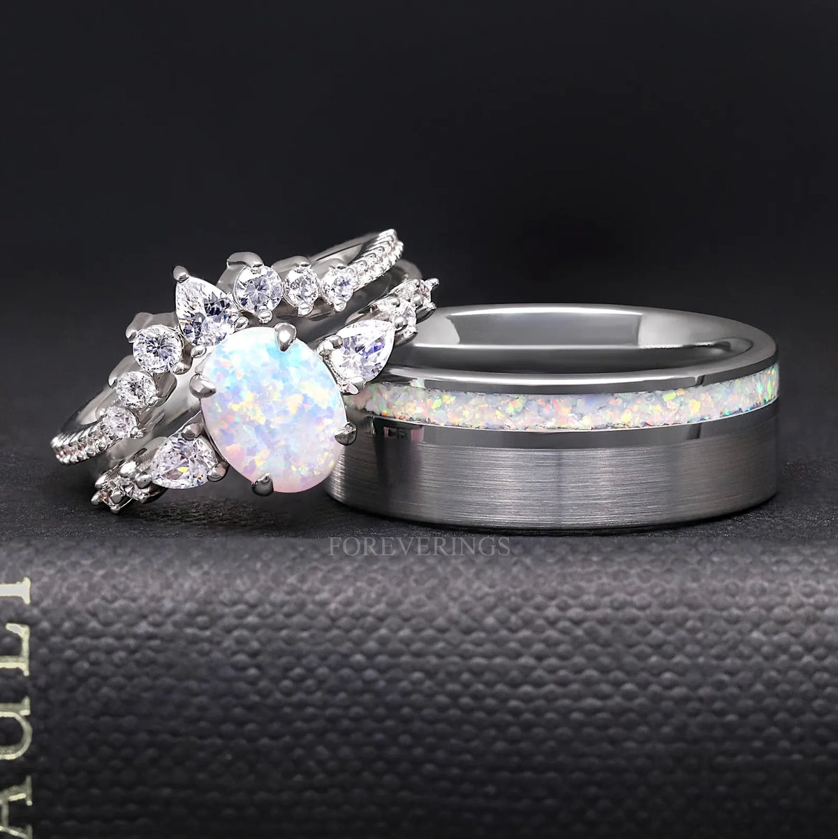 White opal bridal set leaning against a wider brushed silver ring with an opal inlay stripe