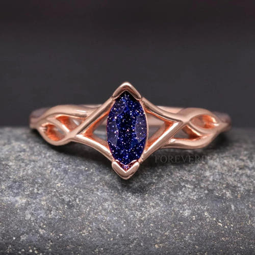 Women's rose gold sterling silver Celtic knot engagement ring with a marquise blue sandstone center