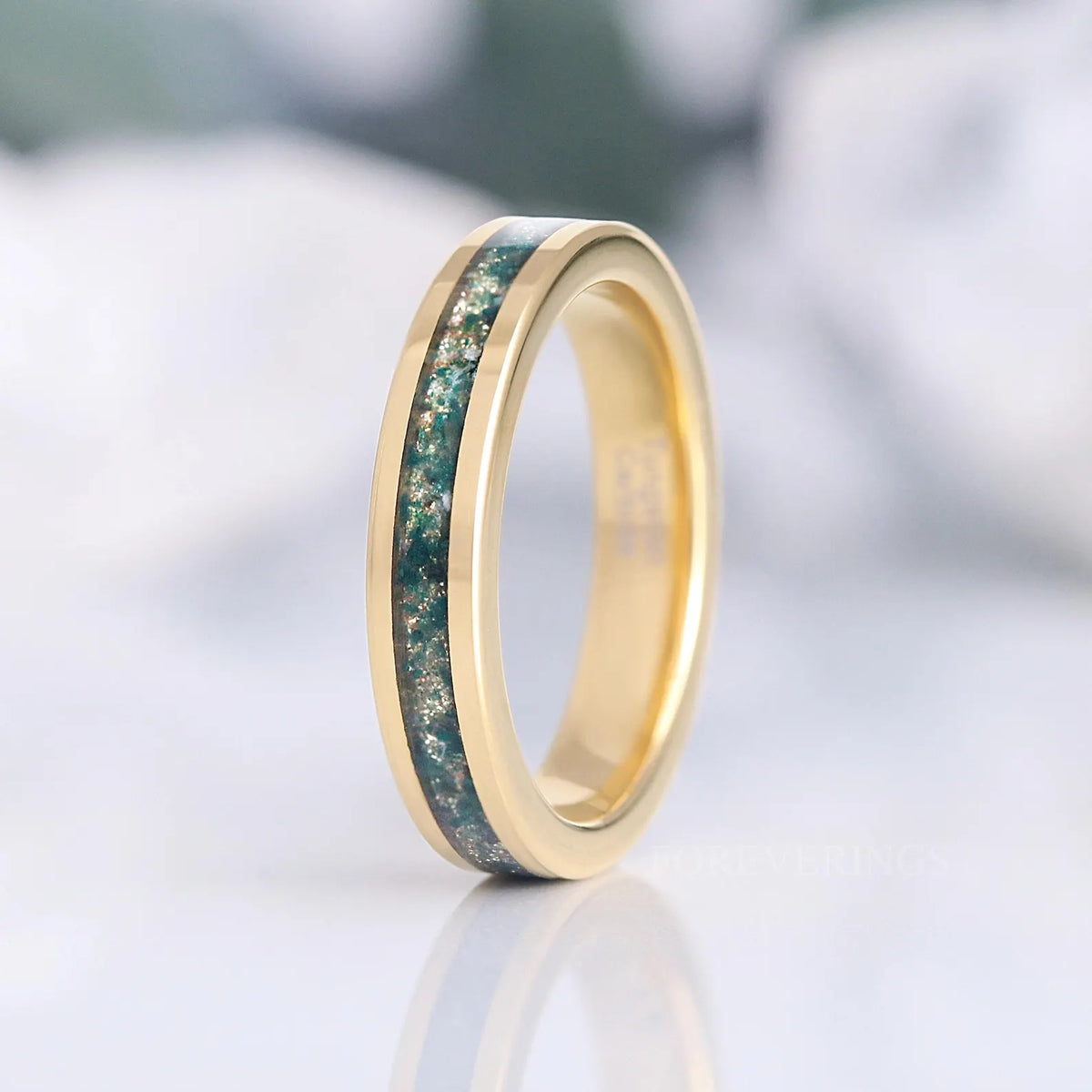 Women's 4mm gold tungsten ring with green moss agate inlay standing upright, polished finish