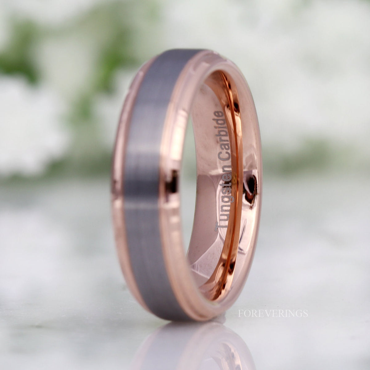 Two-tone tungsten band angled to show the polished rose gold interior