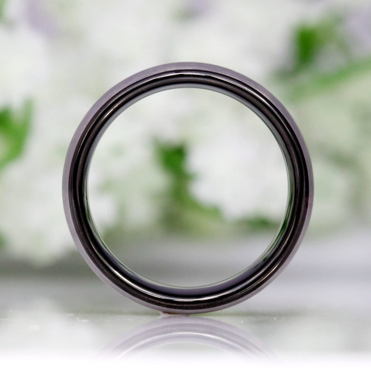 8mm silver and black tungsten band standing on edge, viewed straight through