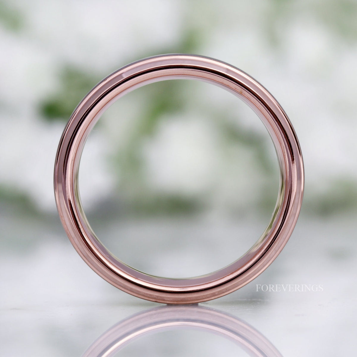 Two-tone tungsten band viewed straight through the center, rose gold inner circle