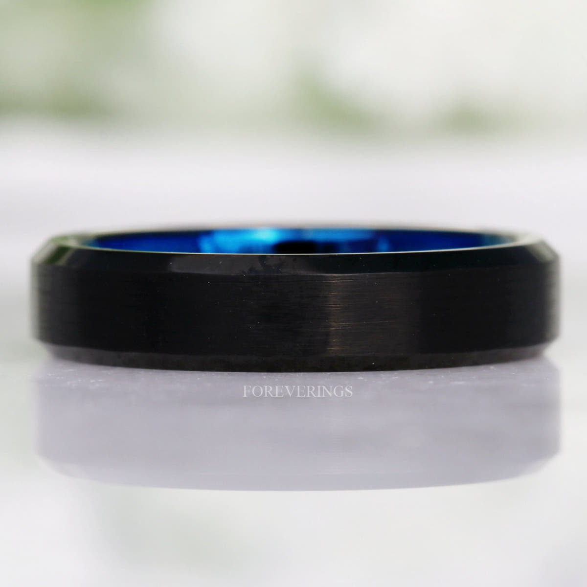 4mm black tungsten ring lying flat, front view showing the blue inner edge