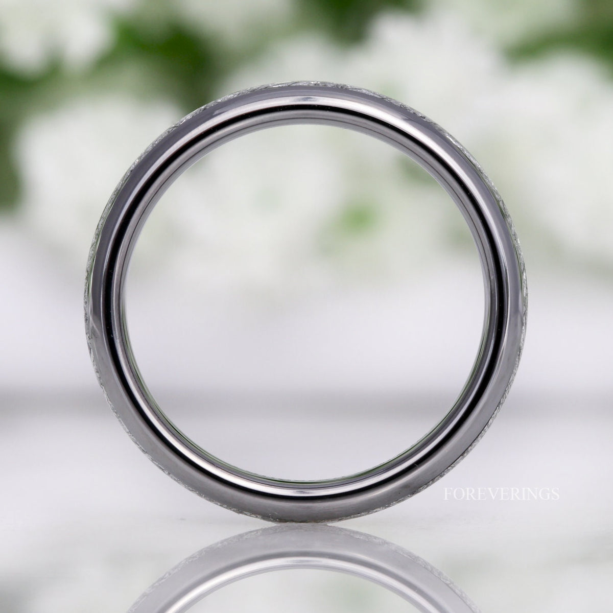 Silver tungsten meteorite-look band standing upright, viewed straight through the center