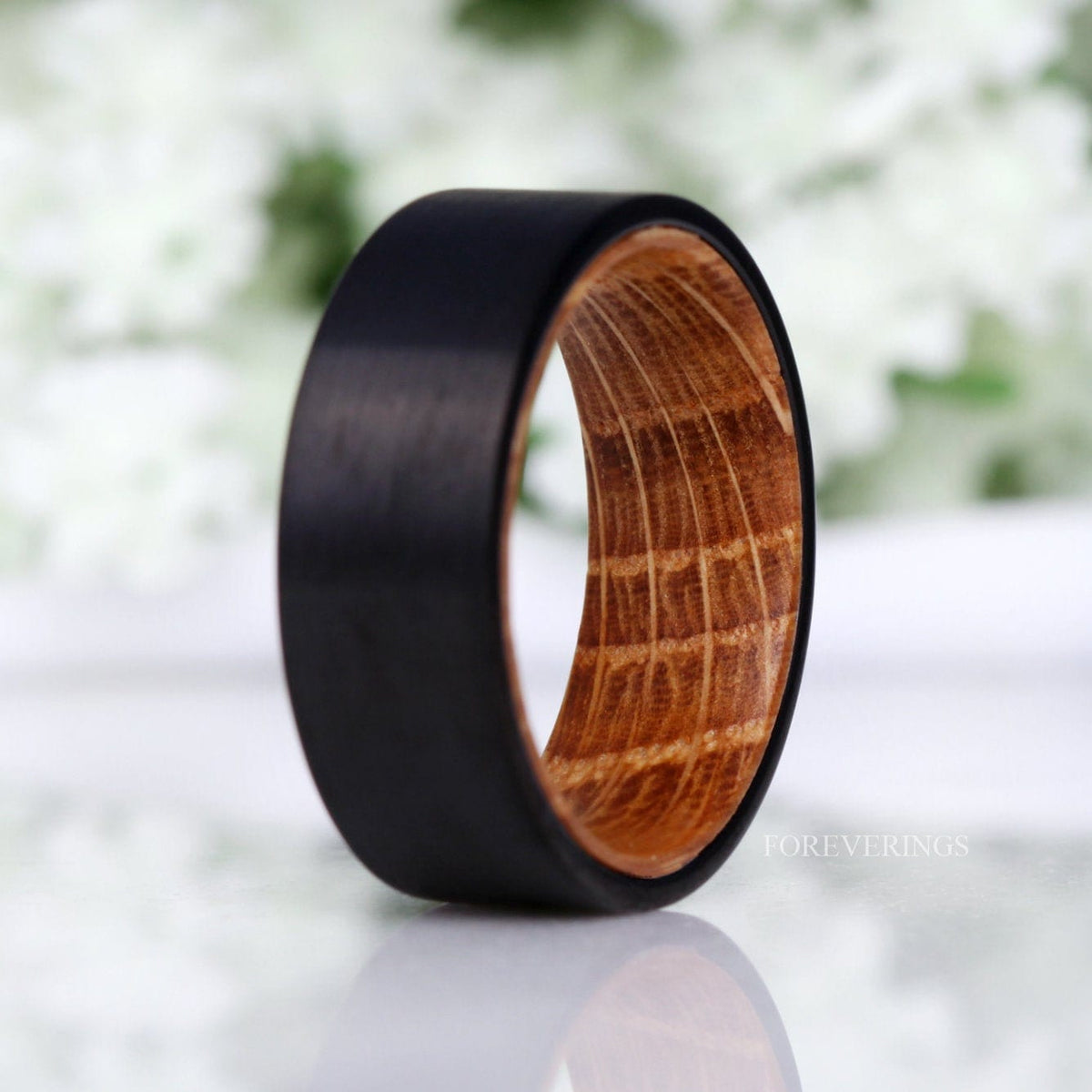 Men's 8mm black tungsten band turned to show the whiskey barrel wood grain inside