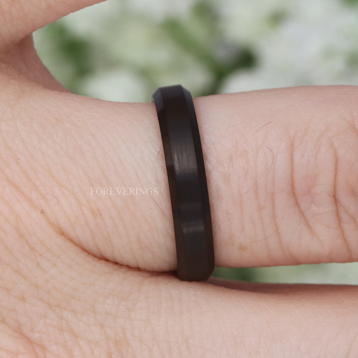Black two-tone tungsten band on a finger, side view of the beveled edge