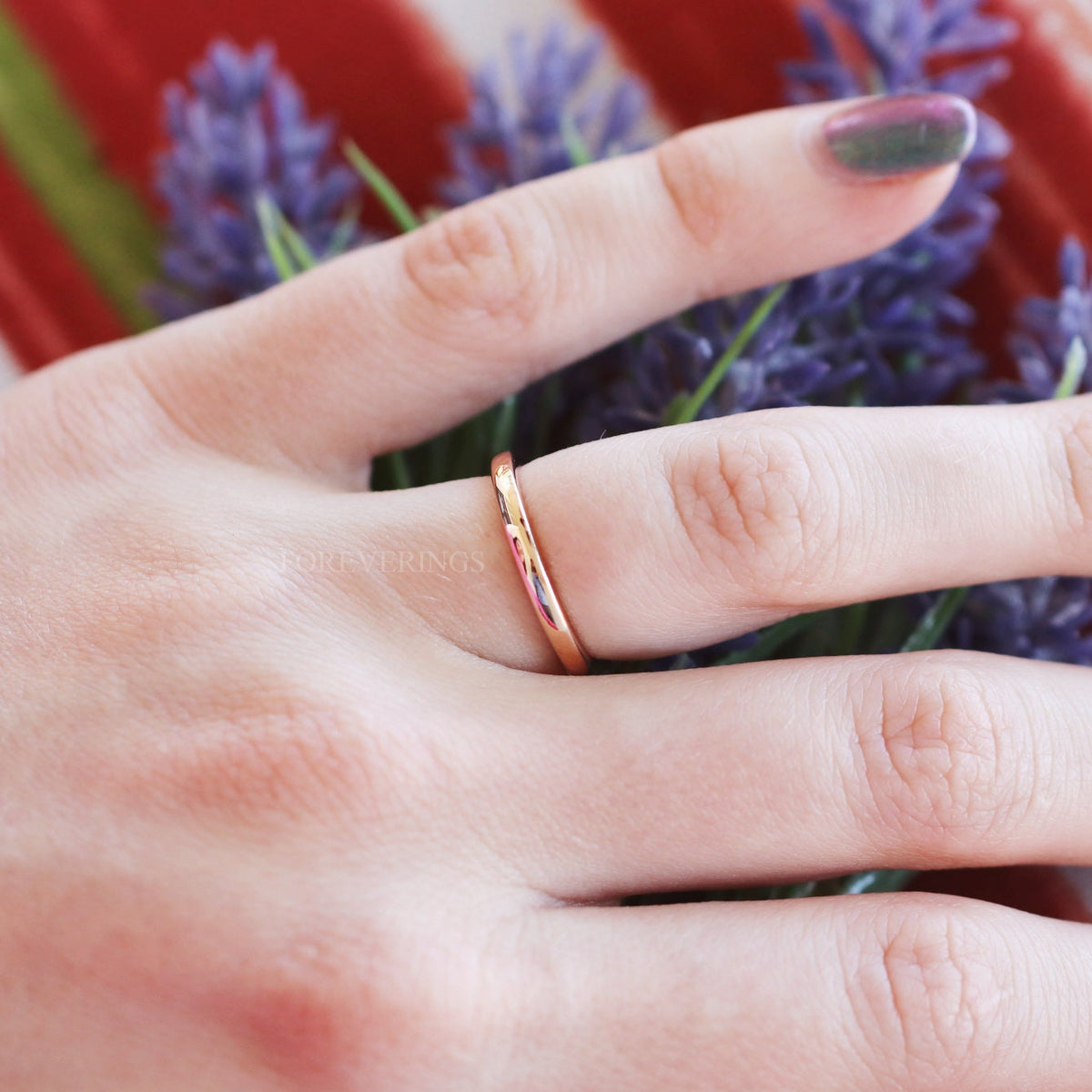 Women's 2mm rose gold tungsten wedding band worn on a hand