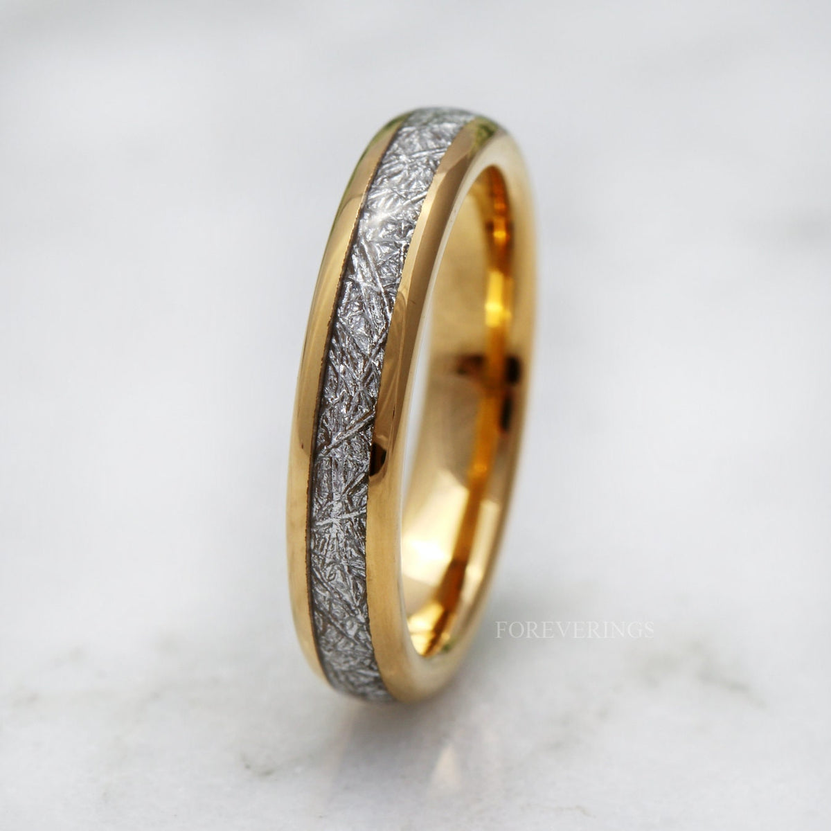 Gold tungsten band with a silver meteorite-look pattern, tilted close crop