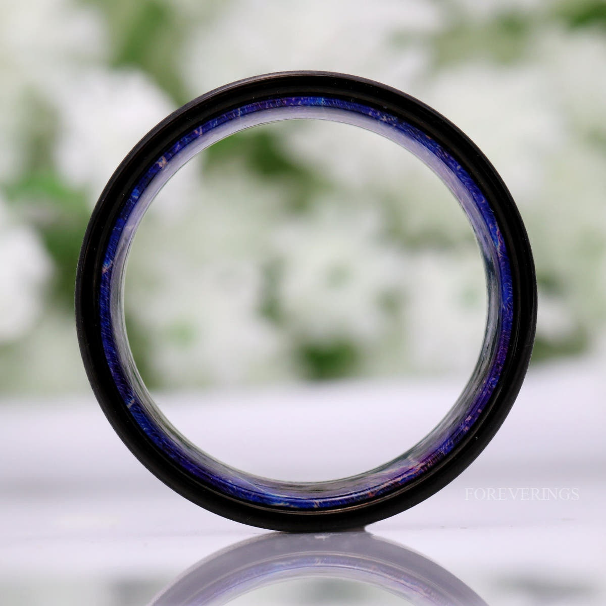 Black tungsten band viewed straight through the center, showing the full blue elder wood lining
