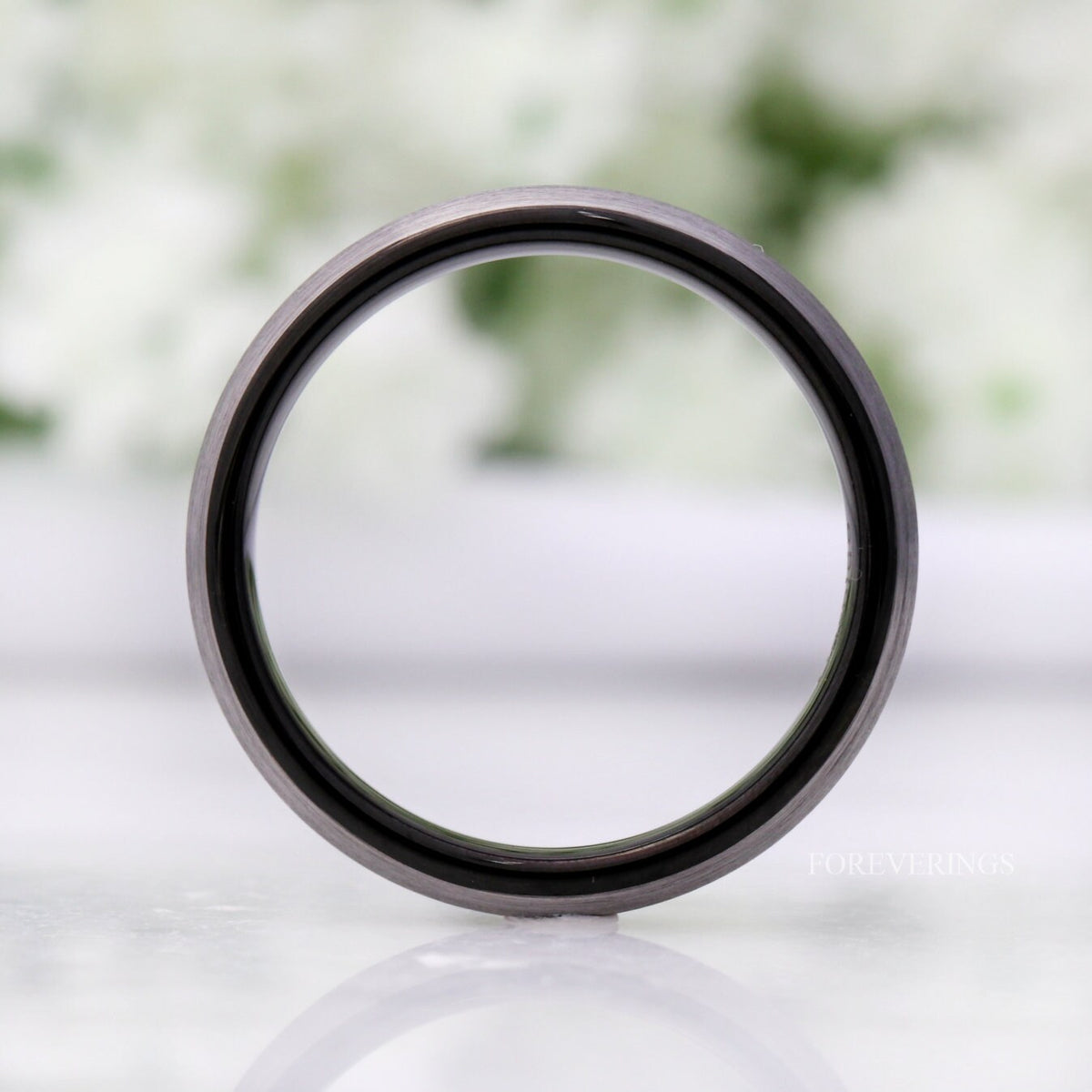 4mm silver tungsten band standing on edge, viewed straight through to the black interior