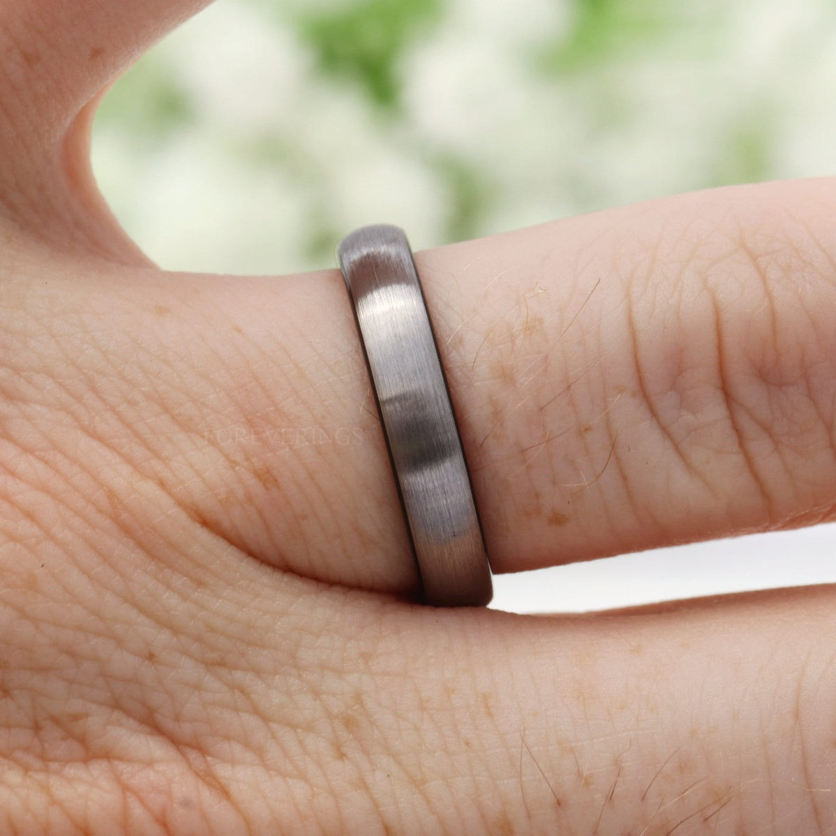 4mm brushed silver and black tungsten band worn on a finger