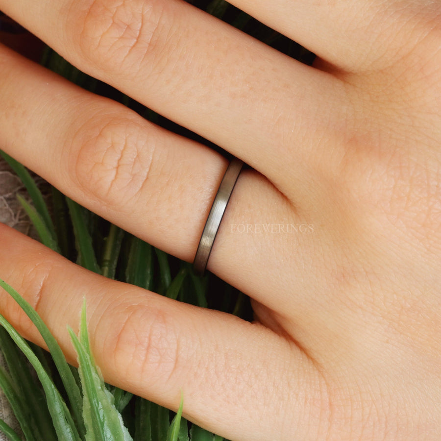 2mm two-tone silver and blue tungsten band worn on a ring finger