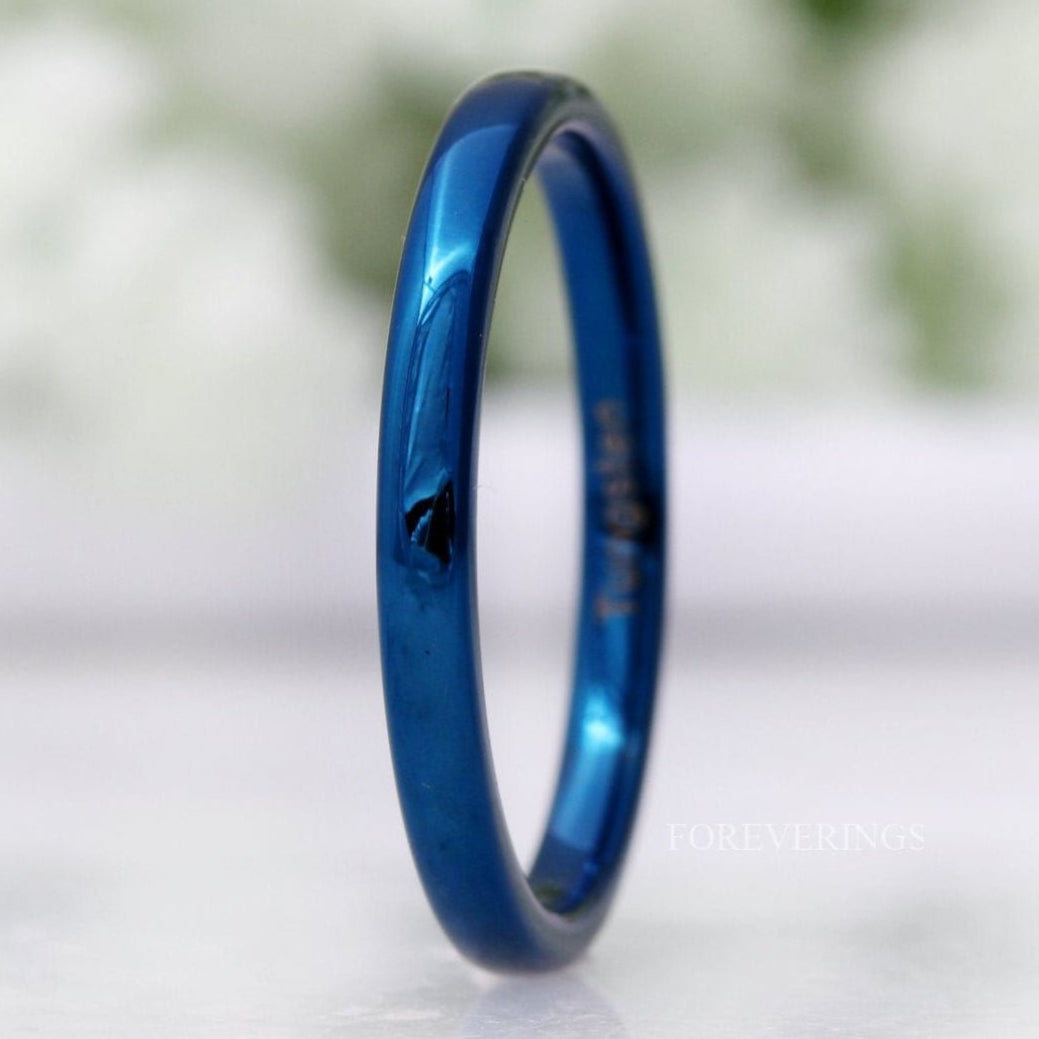Minimalist 2mm blue tungsten wedding band standing on edge, polished dome in a close crop