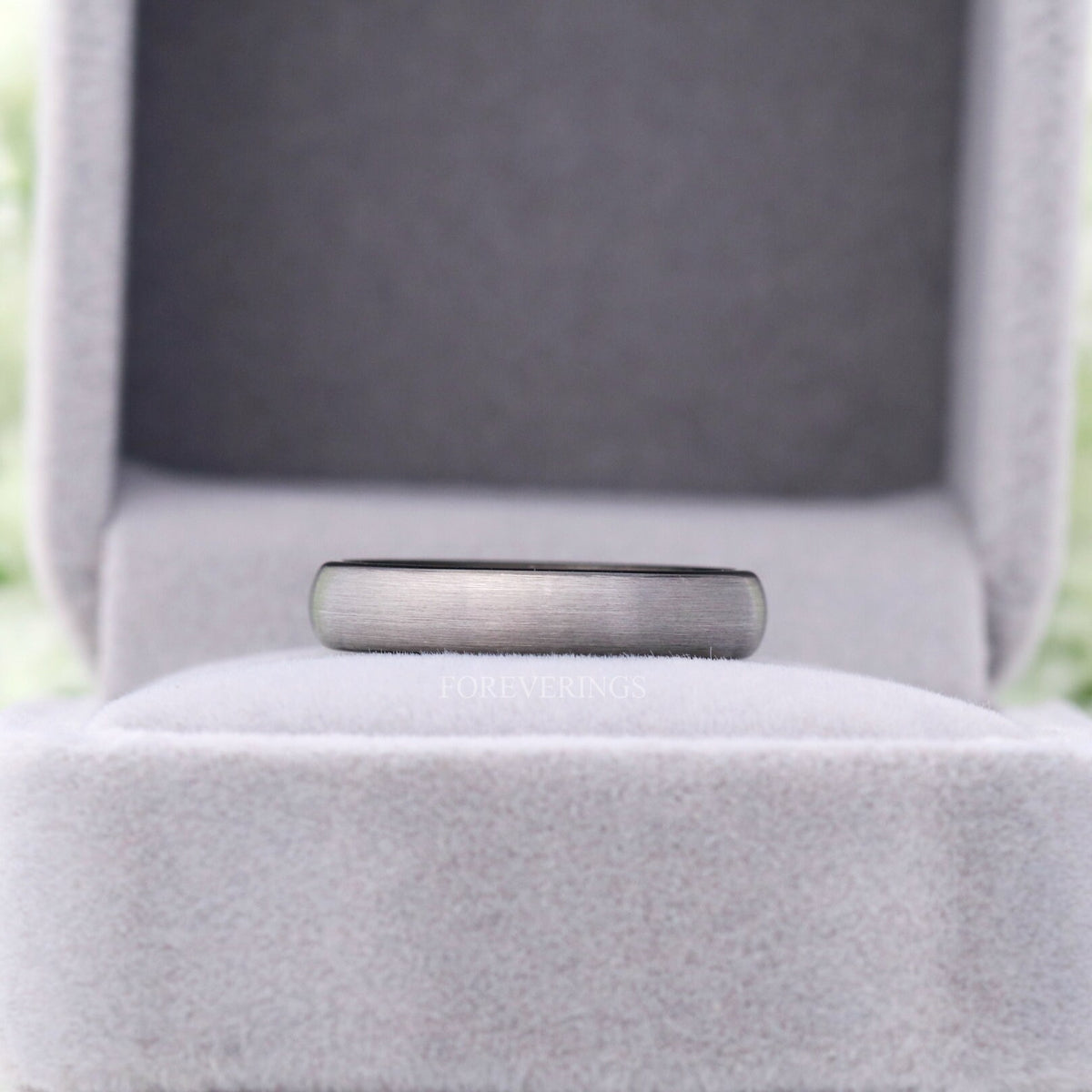 4mm brushed silver tungsten wedding band in a gray velvet ring box