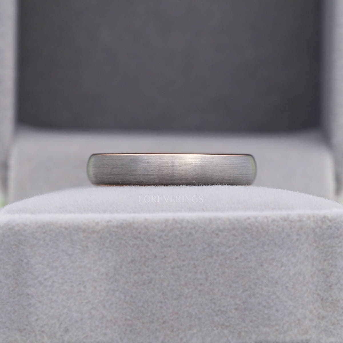 4mm matte silver tungsten dome band shown in a gray velvet ring box