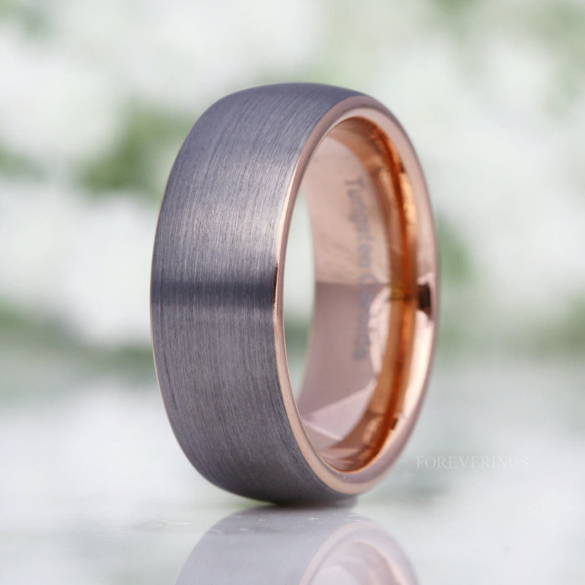 Men's 8mm matte silver tungsten dome band with a rose gold interior, standing at an angle