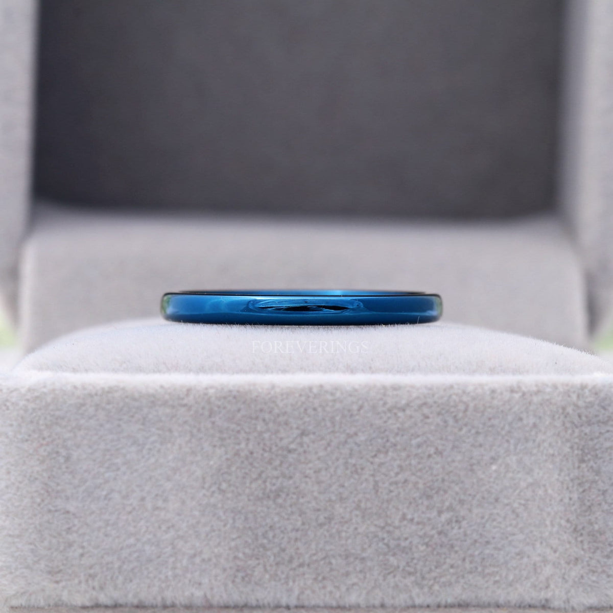 2mm blue tungsten band in a gray velvet ring box