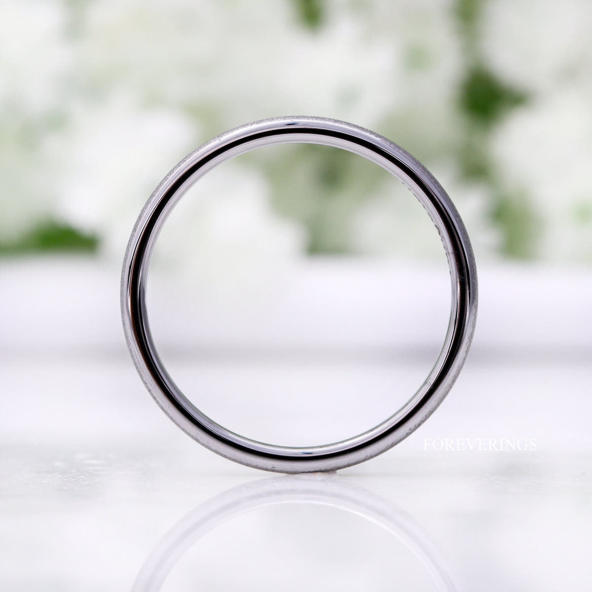 Sandblasted silver tungsten band standing face-on, showing its thin 2mm profile