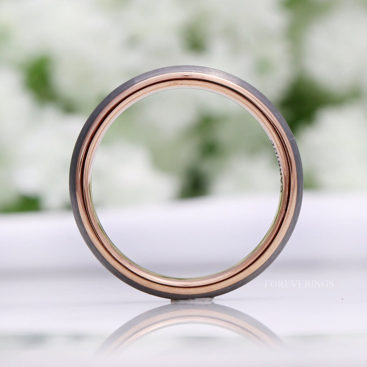 Tungsten band seen straight through, showing the rose gold interior and silver edge