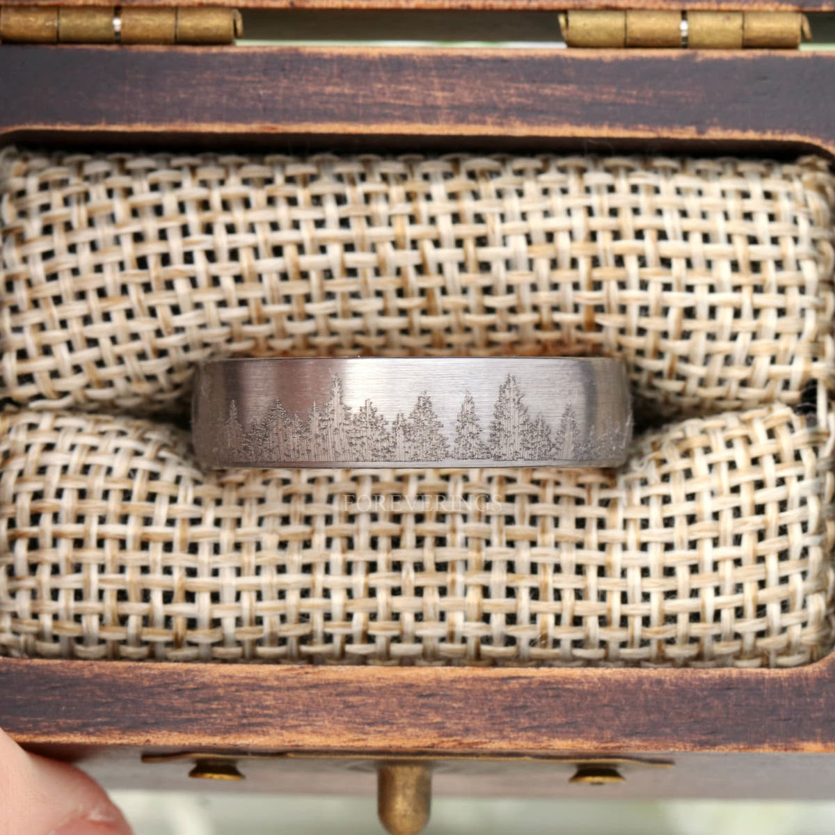 Silver tungsten forest tree-line band in a rustic wood ring box with burlap insert