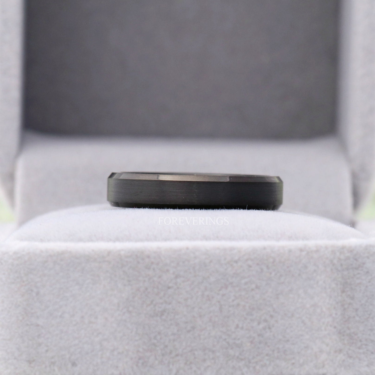 Matte black tungsten band in a gray ring box