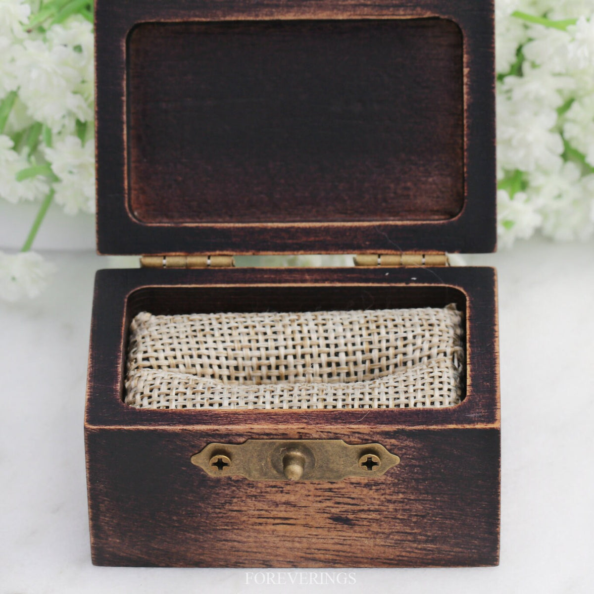 Empty wood ring box opened to show the burlap foam insert and lid