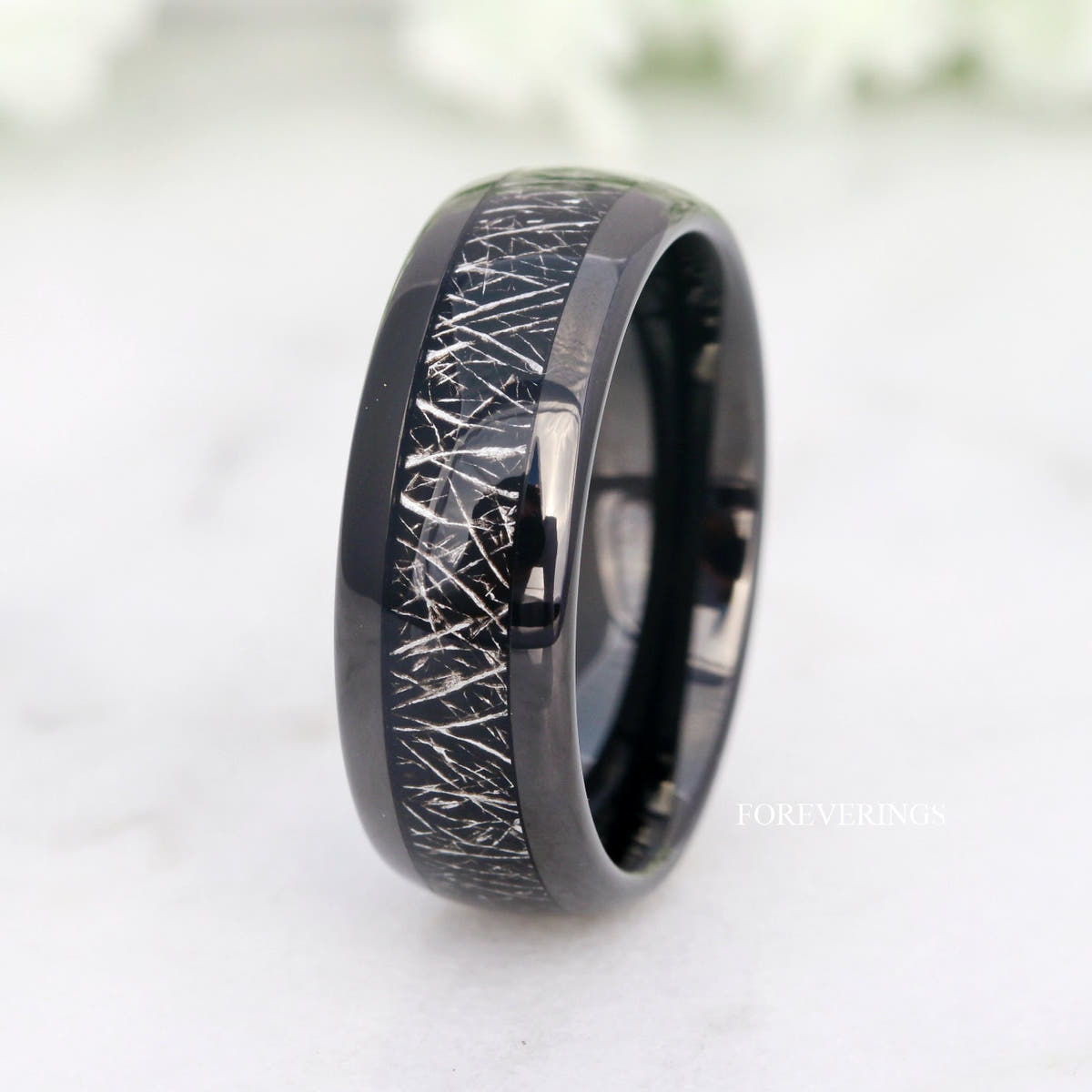 Black tungsten band with meteorite-look inlay standing at an angle, wider view